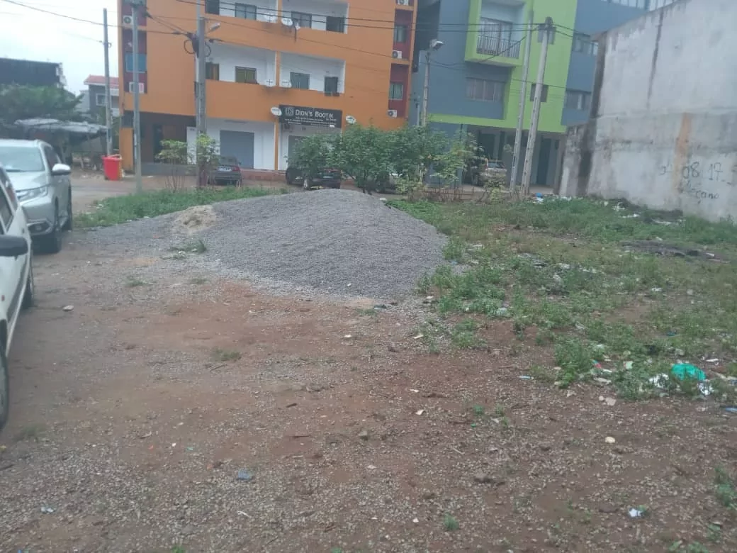 Parcelle plane et clôturée bordée d’immeubles, en pleine ville