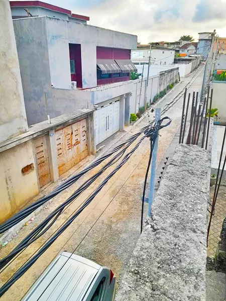 Câbles et réseaux posés le long d’une ruelle bétonnée sur un chantier SIDC-SHILO